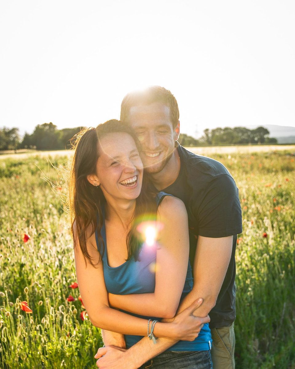 Paar lacht im Mohnfeld beim Fotoshooting