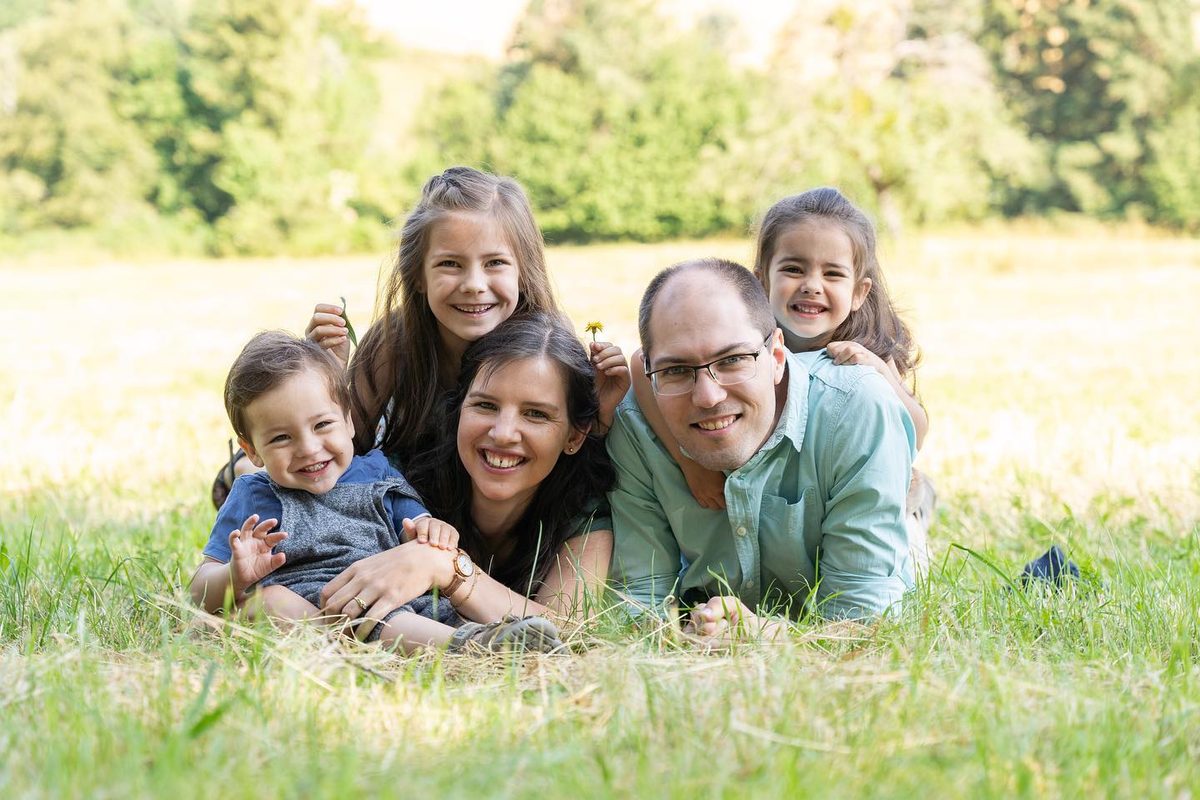 Familie liegt lachend im Gras – Familienshooting